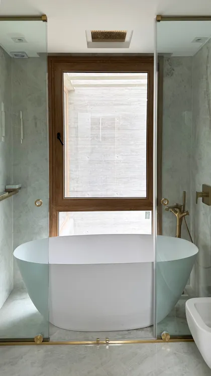 Baño moderno con bañera exenta y ventana grande — proyecto CASA MHN, por Hermann Arquitectos, en Nordelta